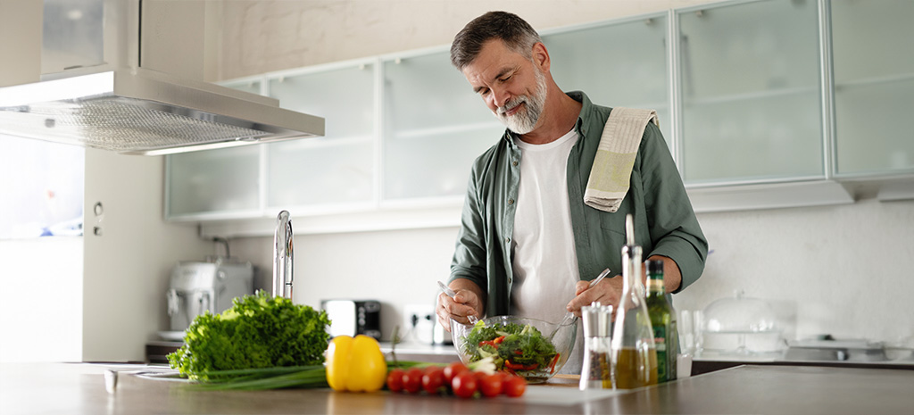 Mann beim Kochen mit frischen Zutaten